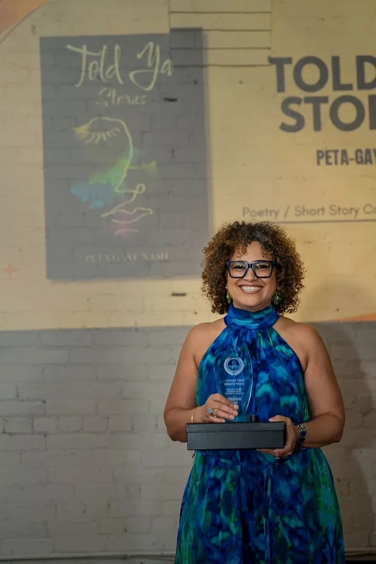 An award recipient holding a trophy in front of the Told Ya! Stories presentation slide.